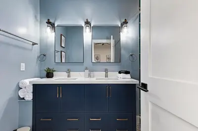 a blue bathroom with a sink and a mirror at The Brick & Beam Boutique Hotel in Collingwood