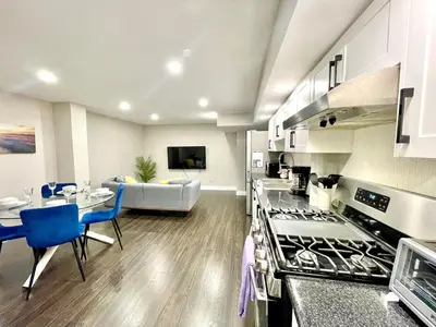 a kitchen and living room with a stove and a couch at Violet Escape Modern Apt 1B 1B, Kitchen, Parking in Richmond Hill