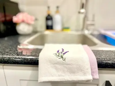 a towel with a flower on it on a kitchen counter at Violet Escape Modern Apt 1B 1B, Kitchen, Parking in Richmond Hill