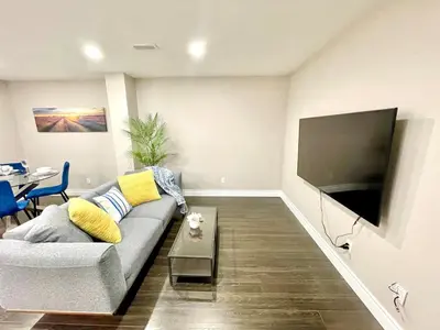 a living room with a couch and a flat screen tv at Violet Escape Modern Apt 1B 1B, Kitchen, Parking in Richmond Hill
