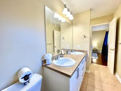 a bathroom with two sinks and a large mirror at Paris Charm Modern 4B3B, Kitchen, Parking,5G in Richmond Hill