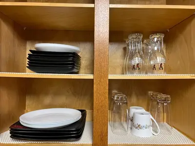 a shelf with plates and glasses and dishes on it at Deluxe Country Escape-Entire Basement Unit in Hamilton