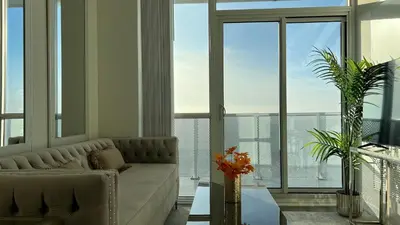 a living room with a couch and large windows at Prestige Upper Series 1-Bedroom Condo at Vaughan Metropolitan Centre in Vaughan