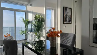 a dining room with a glass table with plants on it at Prestige Upper Series 1-Bedroom Condo at Vaughan Metropolitan Centre in Vaughan