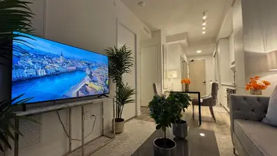 a living room with a large flat screen tv on a wall at Prestige Upper Series 1-Bedroom Condo at Vaughan Metropolitan Centre in Vaughan