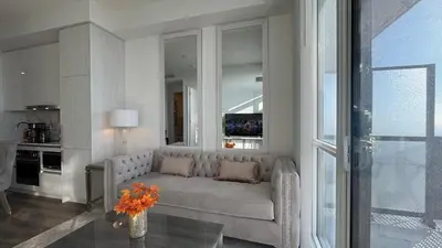 a living room with a couch and a vase with flowers at Prestige Upper Series 1-Bedroom Condo at Vaughan Metropolitan Centre in Vaughan