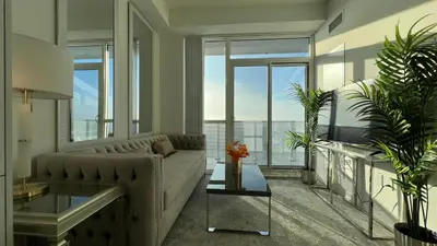 a living room with a couch and some windows at Prestige Upper Series 1-Bedroom Condo at Vaughan Metropolitan Centre in Vaughan