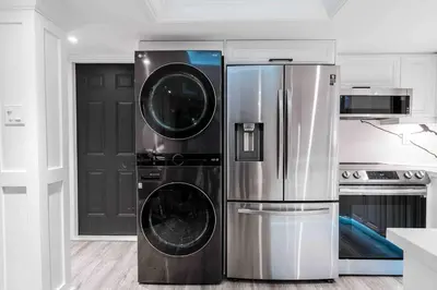 a kitchen with a stainless steel refrigerator with two washing machines at Luxury 2 Bedroom 2Bathroom Modern B Apartment in Ajax, Toronto in Ajax