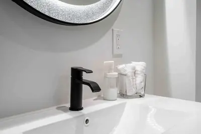 a bathroom sink with a black faucet and a mirror at Luxury 2 Bedroom 2Bathroom Modern B Apartment in Ajax, Toronto in Ajax
