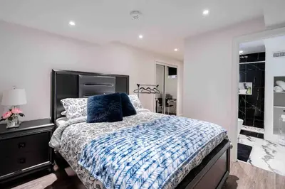 a bedroom with a bed with a blue comforter at Luxury 2 Bedroom 2Bathroom Modern B Apartment in Ajax, Toronto in Ajax