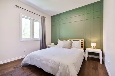 a bedroom with a bed with a green wall at Cozy Couple Retreat | 2 BDR APT | BBQ in Kawartha Lakes