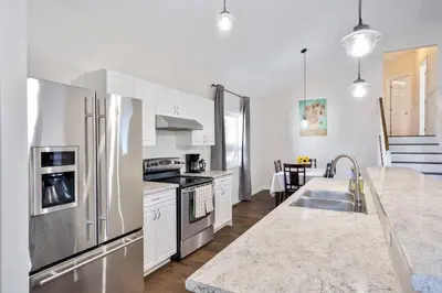 a kitchen with white cabinets and a stainless steel refrigerator at Cozy Couple Retreat | 2 BDR APT | BBQ in Kawartha Lakes