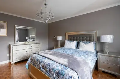 a bedroom with a large bed and a chandelier at Spacious Bright Home In Woodbridge in Vaughan