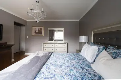a bedroom with a large bed and a chandelier at Spacious Bright Home In Woodbridge in Vaughan
