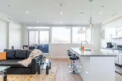 a kitchen and living room with a couch and a table at Westend Suites - Bright & Inviting 3BR Hotel near High Park in Toronto