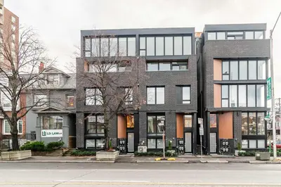 a large brick building on a city street at Westend Suites - Bright & Inviting 3BR Hotel near High Park in Toronto