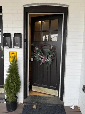 a black front door with a wreath on it at The Maple and Mist in Niagara Falls