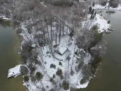 an aerial view of an island with trees and snow at Lake Eugenia Escape - Cozy Lakefront with Hot Tub in Flesherton