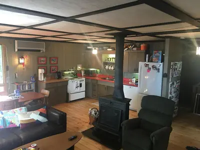 a living room with a stove in a kitchen at Lake Eugenia Escape - Cozy Lakefront with Hot Tub in Flesherton
