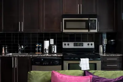 a kitchen with a stove and a microwave at Live the excitement Stay next to Scotiabank Arena! in Toronto