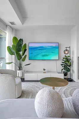 a living room with a tv on a wall at Charming lakeview suite with parking in Toronto