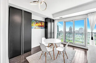 a dining room with a table and chairs and a window at Charming lakeview suite with parking in Toronto