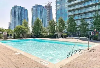a large swimming pool with tall buildings in the background at Charming lakeview suite with parking in Toronto