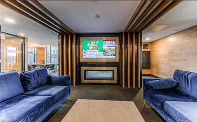 a living room with two blue couches and a tv at Cozy 2BD Near UW in Waterloo