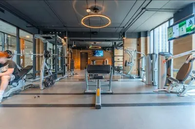a gym with cardio equipment and a woman sitting on a treadmill at Cozy 2BD Near UW in Waterloo