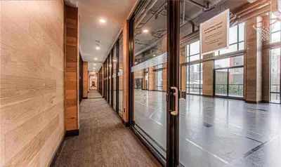 an empty hallway of a building with a glass door at Cozy 2BD Near UW in Waterloo