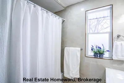 a bathroom with a shower curtain and a window at 132 chatham ave in Toronto