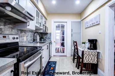 a kitchen with a sink and a table with chairs at 132 chatham ave in Toronto