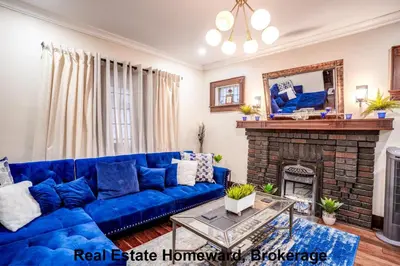 a blue couch in a living room with a fireplace at 132 chatham ave in Toronto