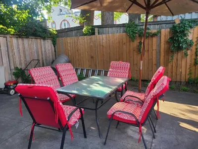 a table and chairs with an umbrella on a patio at 132 chatham ave in Toronto