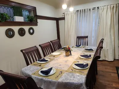 a dining room table with chairs and a long table with plates at 132 chatham ave in Toronto