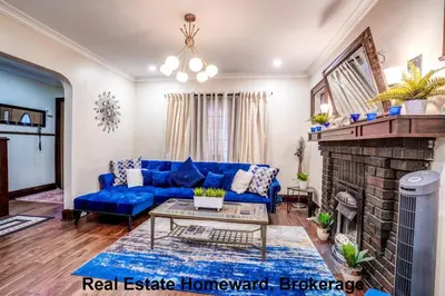 a living room with a blue couch and a fireplace at 132 chatham ave in Toronto
