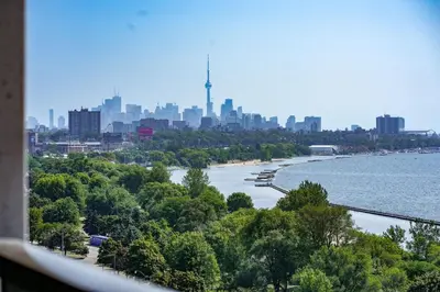 a view of a river with a city in the background at Beachside 2 Bedroom Suite with CN Tower, lake View, and Parking! in Toronto