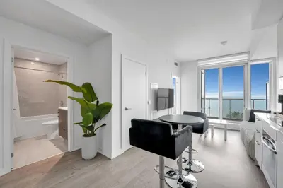 a kitchen with a table and chairs in a room at Beachside 2 Bedroom Suite with CN Tower, lake View, and Parking! in Toronto