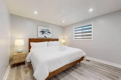 a bedroom with a large white bed and a window at 10 Acre Farmhouse with Pool + 5 Bedrooms/3 Baths in East Gwillimbury