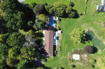 an aerial view of a yard with a house and trees at 10 Acre Farmhouse with Pool + 5 Bedrooms/3 Baths in East Gwillimbury
