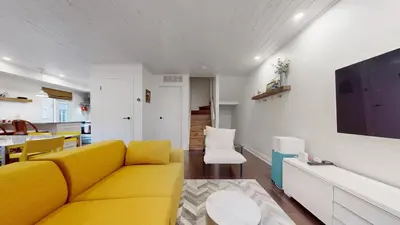 a living room with a yellow couch and a kitchen at Liberty Village-BMO Field-Roof Patio-Parking in Toronto