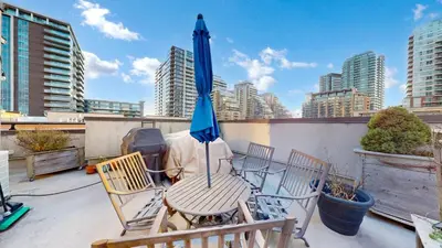 a patio with a table and chairs and an umbrella at Liberty Village-BMO Field-Roof Patio-Parking in Toronto