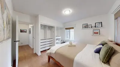 a white bedroom with a large bed and a window at Liberty Village-BMO Field-Roof Patio-Parking in Toronto