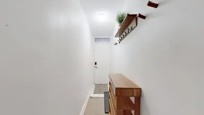 a hallway with a table and a white wall at Liberty Village-BMO Field-Roof Patio-Parking in Toronto