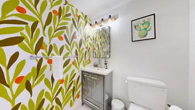 a bathroom with a toilet and a mural on the wall at Liberty Village-BMO Field-Roof Patio-Parking in Toronto