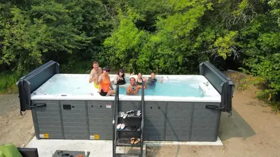 a group of people sitting in a swimming pool at Best Location Chalet Walk to Village-Ski in Ski out Extra Large Hottub in Blue Mountains