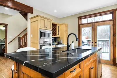 a kitchen with a large black counter top at Best Location Chalet Walk to Village-Ski in Ski out Extra Large Hottub in Blue Mountains