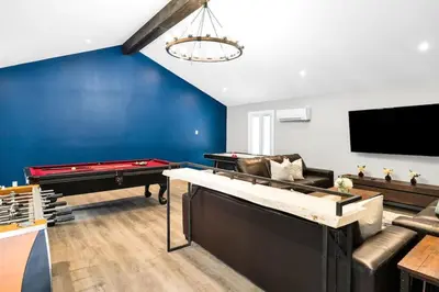 a living room with a couch and a pool table at Best Location Chalet Walk to Village-Ski in Ski out Extra Large Hottub in Blue Mountains