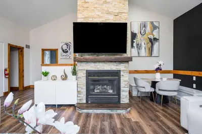 a living room with a fireplace and a flat screen tv at Large chalet 3 King bed Sauna-Hot Tubs Projector in Blue Mountains