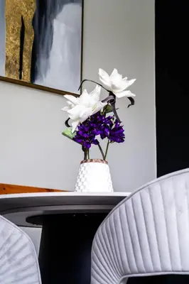 a vase filled with flowers on a table at Large chalet 3 King bed Sauna-Hot Tubs Projector in Blue Mountains